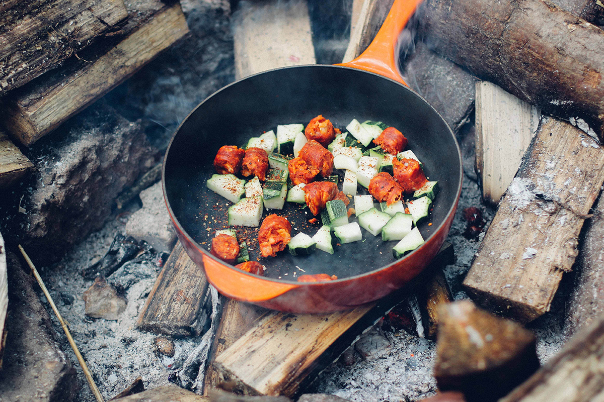 Cucinare con una padella sul fuoco.